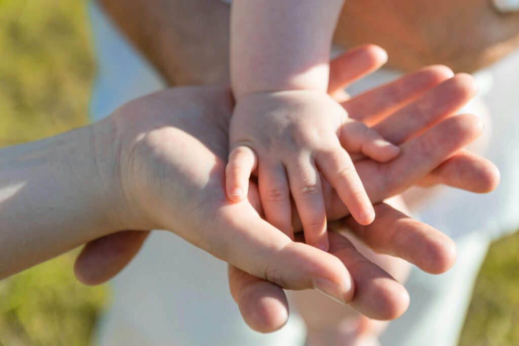 family holding baby hands symbolizing child adoption in Idaho